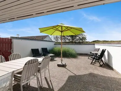 a patio with a table and a yellow umbrella at Holiday Home Ara - 700m from the sea by Interhome in Pandrup