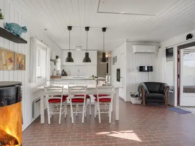 a kitchen with a white table and chairs in a room at Holiday Home Marjon - 400m from the sea by Interhome in Pandrup