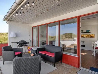 a patio with chairs and a table and a grill at Holiday Home Marjon - 400m from the sea by Interhome in Pandrup