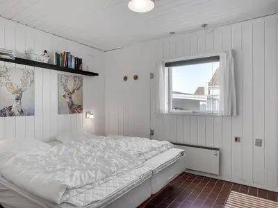 a bedroom with a white bed and a window at Holiday Home Marjon - 400m from the sea by Interhome in Pandrup