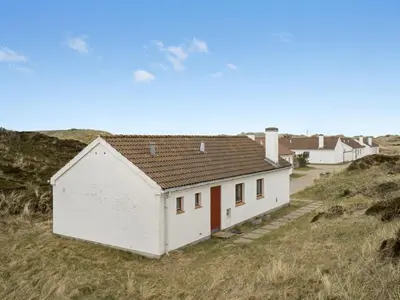 a white house on the side of a hill at Holiday Home Emiljan - 400m from the sea by Interhome in Pandrup