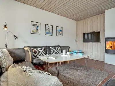 a living room with a couch and a table at Holiday Home Emiljan - 400m from the sea by Interhome in Pandrup