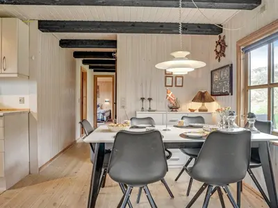 a kitchen and dining room with a table and chairs at Holiday Home Marite - 200m from the sea by Interhome in Pandrup
