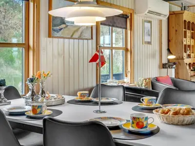a dining room with a table and chairs at Holiday Home Marite - 200m from the sea by Interhome in Pandrup