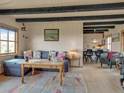a living room with a blue couch and a table at Holiday Home Marite - 200m from the sea by Interhome in Pandrup