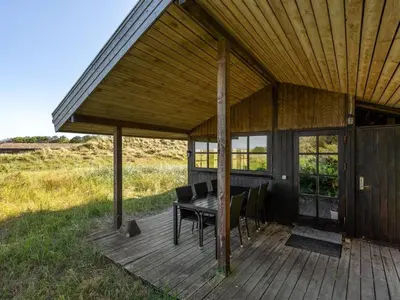 a wooden deck with a table and chairs on it at Holiday Home Marite - 200m from the sea by Interhome in Pandrup