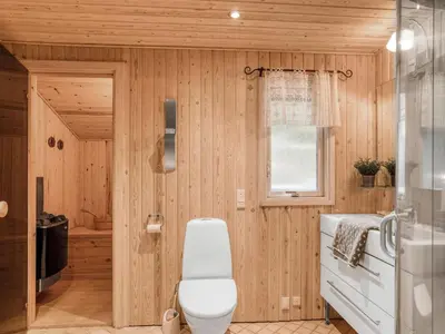 a bathroom with a white toilet and a window at Holiday Home Birghir - 1-5km from the sea by Interhome in Blokhus