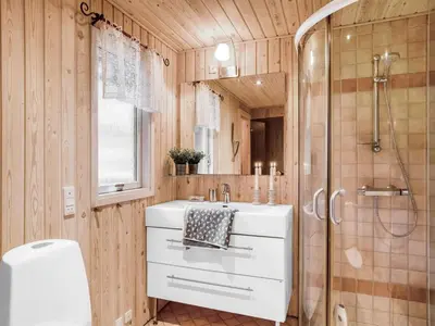 a bathroom with a white sink and a shower at Holiday Home Birghir - 1-5km from the sea by Interhome in Blokhus