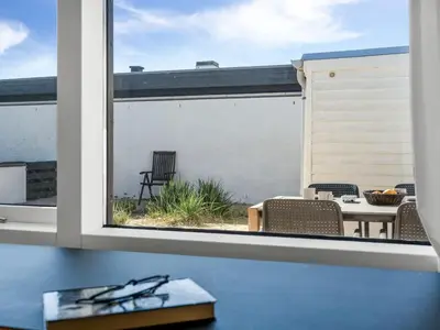 a window view of a patio with a table and chairs at Holiday Home Ingomar - 300m from the sea by Interhome in Pandrup