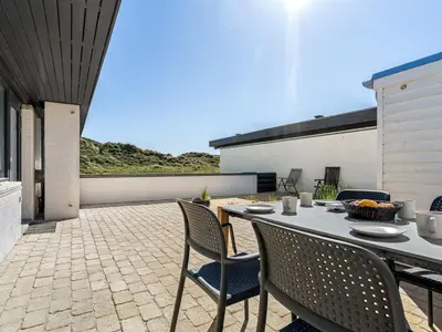 a patio with a table and chairs on a patio at Holiday Home Ingomar - 300m from the sea by Interhome in Pandrup