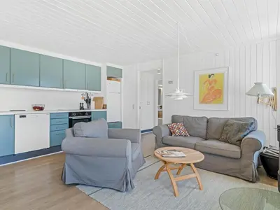 a living room with two couches and a table at Holiday Home Ingomar - 300m from the sea by Interhome in Pandrup