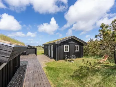 a black shed with a walkway in a yard at Holiday Home Driss - 500m from the sea by Interhome in Pandrup