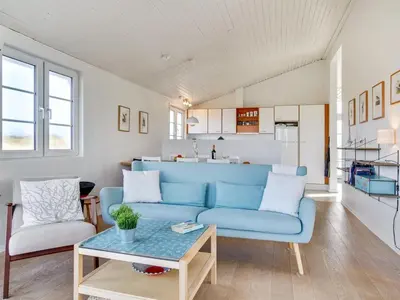 a living room with a blue couch and a table at Holiday Home Zaharinka - 300m from the sea by Interhome in Pandrup