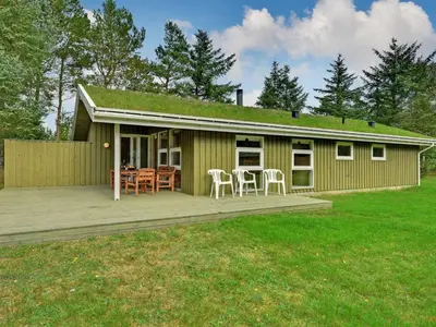 a house with a deck with a table and chairs at Holiday Home Editt - 2km from the sea by Interhome in Pandrup
