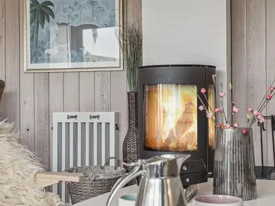 a room with a heater and a vase with flowers at Holiday Home Viena - 400m from the sea by Interhome in Pandrup