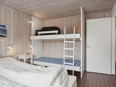 a bedroom with a bunk bed with a ladder and a bunk bedouble at Holiday Home Viena - 400m from the sea by Interhome in Pandrup