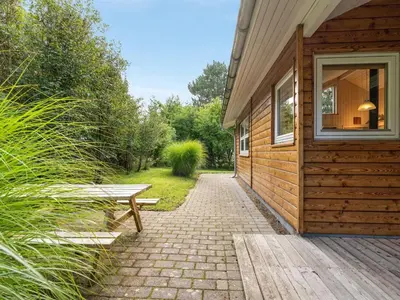 a wooden building with a bench next to it at Holiday Home Krister - 250m to the fjord by Interhome in Farsø