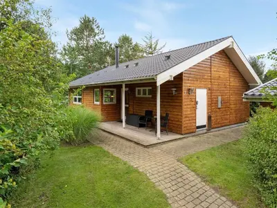 a wooden house with a porch and a patio at Holiday Home Krister - 250m to the fjord by Interhome in Farsø