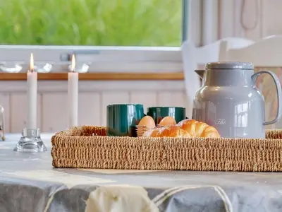 a basket of bread and eggs on a table with candles at Holiday Home Krister - 250m to the fjord by Interhome in Farsø
