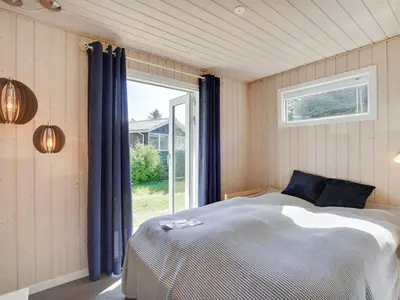 a bedroom with a bed in front of a window at Holiday Home Josefiina - 450m to the fjord by Interhome in Løgsted