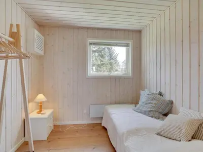 a small bedroom with a bed and a window at Holiday Home Josefiina - 450m to the fjord by Interhome in Løgsted