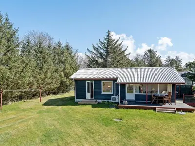 a blue tiny house with a porch and a yard at Holiday Home Josefiina - 450m to the fjord by Interhome in Løgsted