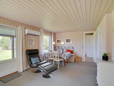 a living room with a table and a chair at Holiday Home Josefiina - 450m to the fjord by Interhome in Løgsted