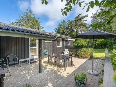 a patio with a table and an umbrella at Holiday Home Angantir - 700m to the fjord by Interhome in Løgstør