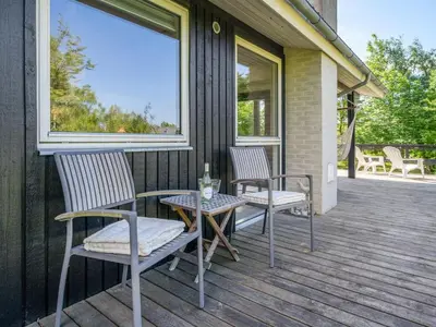 two chairs and a table on a porch at Holiday Home Angantir - 700m to the fjord by Interhome in Løgstør