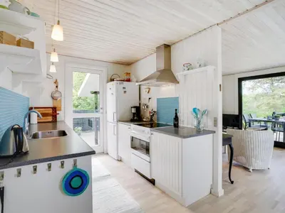 a kitchen with white cabinets and a large window at Holiday Home Angantir - 700m to the fjord by Interhome in Løgstør