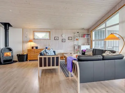 a living room with a couch and a fireplace at Holiday Home Awenita - 50m to the fjord by Interhome in Løgsted