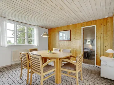 a dining room with a wooden table and chairs at Holiday Home Githa - 100m to the fjord by Interhome in Løgstør
