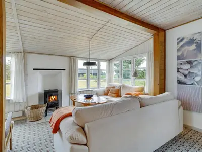 a living room with a white couch and a fireplace at Holiday Home Githa - 100m to the fjord by Interhome in Løgstør