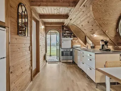 a kitchen with wooden walls and wooden flooring at Holiday Home Tally - 800m to the fjord by Interhome in Løgsted