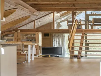a living room with wooden ceilings and a table and chairs at Holiday Home Tally - 800m to the fjord by Interhome in Løgsted