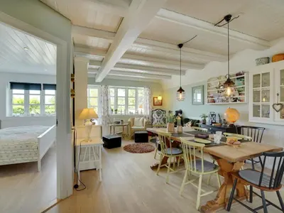 a kitchen and living room with a table and chairs at Holiday Home Tamer - 500m to the fjord by Interhome in Farsø