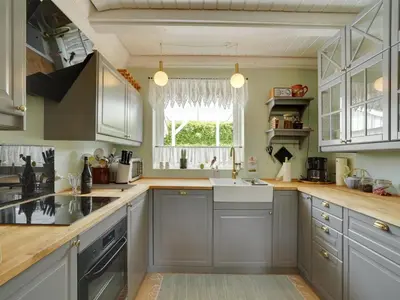 a kitchen with gray cabinets and a sink and a window at Holiday Home Tamer - 500m to the fjord by Interhome in Farsø