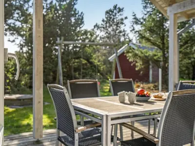 a wooden table and chairs on a deck at Holiday Home Anethe - 100m to the fjord by Interhome in Løgstør
