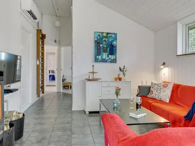 a living room with a orange couch and a table at Holiday Home Marlien - 1km to the fjord by Interhome in Løgsted