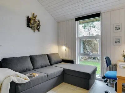 a living room with a couch and a window at Holiday Home Marlien - 1km to the fjord by Interhome in Løgsted