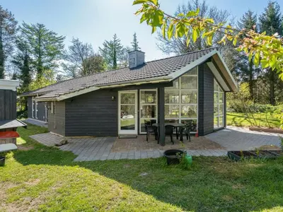 a small house with a patio and a table at Holiday Home Marlien - 1km to the fjord by Interhome in Løgsted