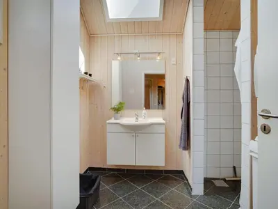 a bathroom with a sink and a mirror at Holiday Home Eireen - 600m to the fjord by Interhome in Farsø