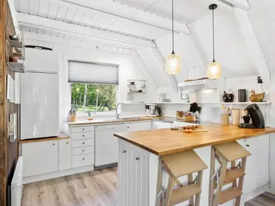 a kitchen with white cabinets and a wooden counter top at Holiday Home Jütte - 2km to the fjord by Interhome in Farsø