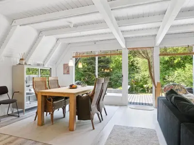 a dining room with a wooden table and chairs at Holiday Home Jütte - 2km to the fjord by Interhome in Farsø