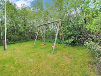 a swing set in a field with two frisbees at Holiday Home Gesina - 600m to the fjord by Interhome in Løgstør