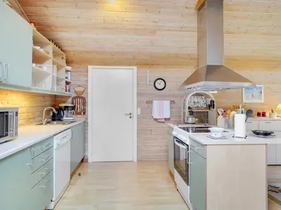a kitchen with wooden walls and white counters at Holiday Home Magh by Interhome in Års