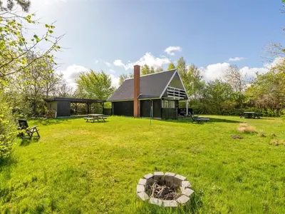 a house in the middle of a yard with a fire pit at Holiday Home Thina - 750m to the fjord by Interhome in Løgsted
