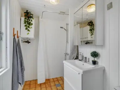a white bathroom with a sink and a shower at Holiday Home Thina - 750m to the fjord by Interhome in Løgsted