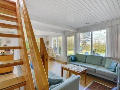 a living room with a couch and a staircase at Holiday Home Thina - 750m to the fjord by Interhome in Løgsted