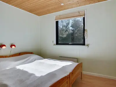 a bedroom with a bed and a window at Holiday Home Ludde - 500m to the fjord by Interhome in Løgstør